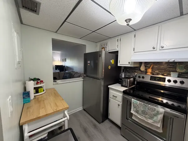 a kitchen with sink refrigerator and cabinets