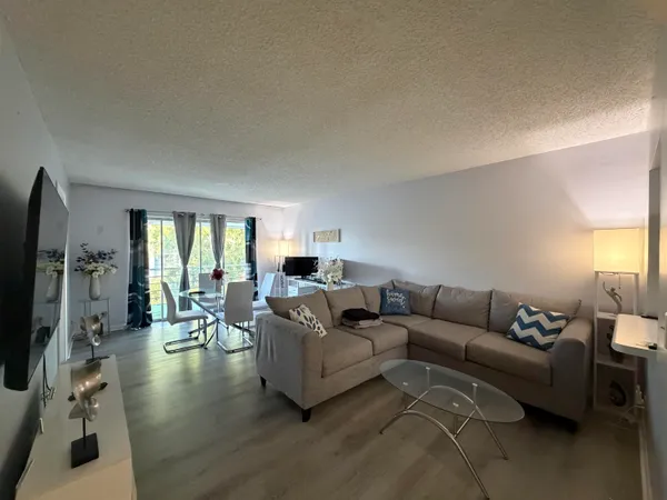 a living room with furniture window and a flat screen tv