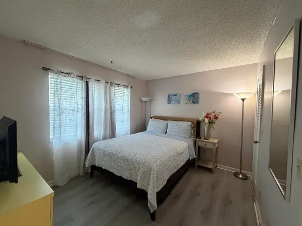 a bedroom with a bed and large mirror