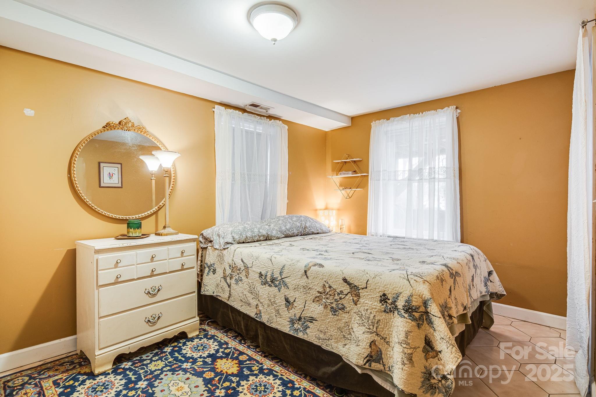 195 Whitmire Road Brevard, NC 28712 - Photo 16 of 30 a bedroom with a bed and a mirror on the dresser