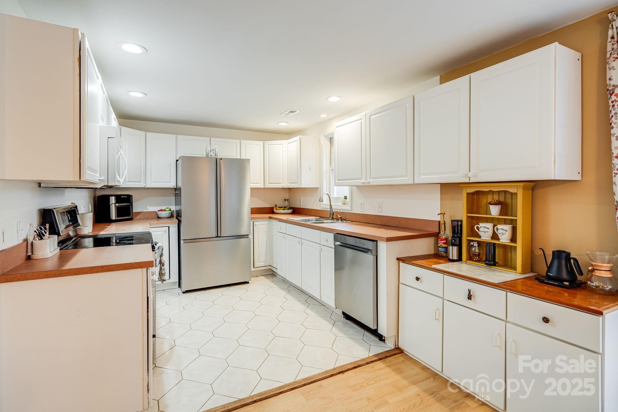 195 Whitmire Road Brevard, NC 28712 - Photo 7 of 30 a kitchen with refrigerator cabinets and white appliances