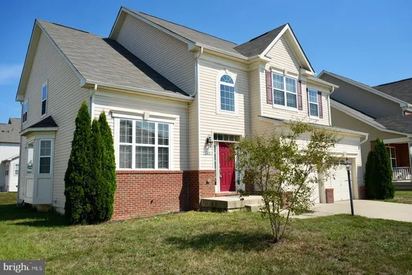 a front view of a house with a yard and plants