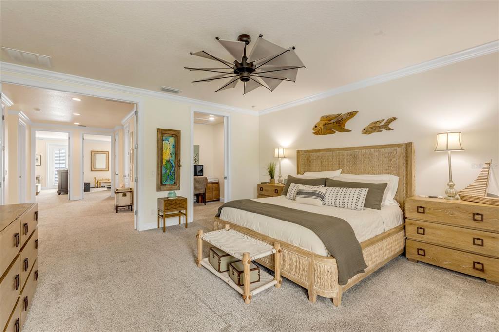 123 Marina Bay Drive New Smyrna Beach, FL 32169 - Photo 38 of 84 a spacious bedroom with a bed a chandelier and closet