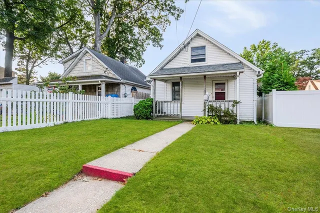 a front view of a house with a yard and trees
