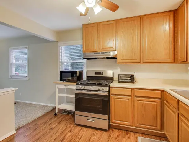a kitchen with granite countertop wooden cabinets stainless steel appliances and a sink