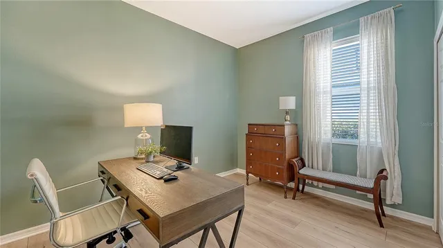 a view of a workspace with furniture and a window