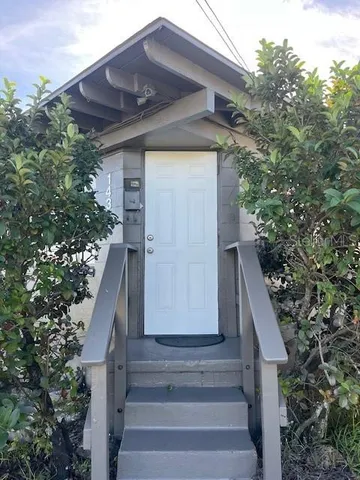 a view of a pathway of a house with large trees