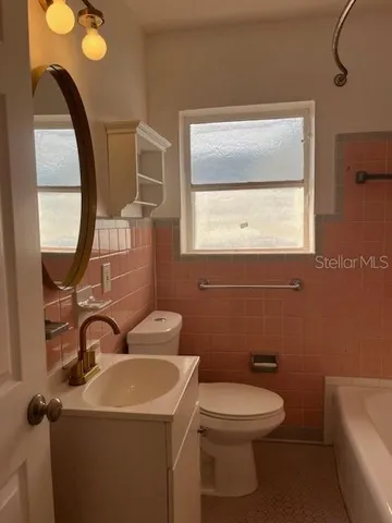 a bathroom with a toilet sink and mirror