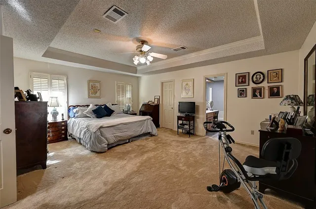 a bedroom with a bed gym equipment and view of living room