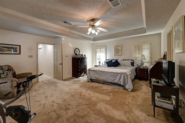 a spacious bedroom with a bed a desk and chair