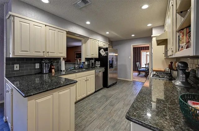 a kitchen with stainless steel appliances granite countertop a stove sink and cabinets
