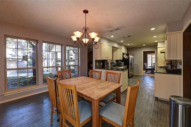 a view of a dining room and livingroom with furniture wooden floor a chandelier
