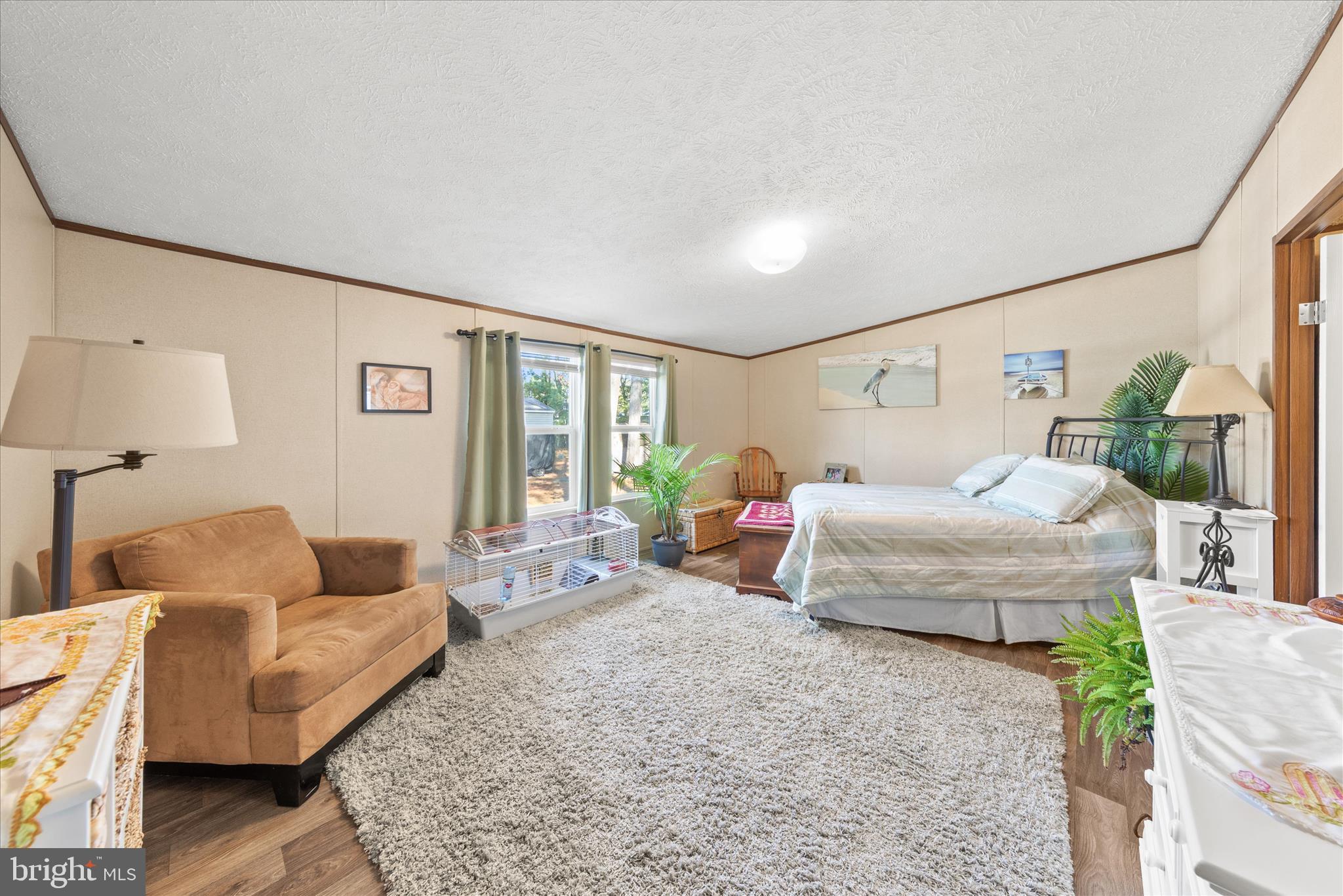 27297 Waters Edge Road Millsboro, DE 19966 - Photo 19 of 46 a spacious bedroom with a bed couch and a window