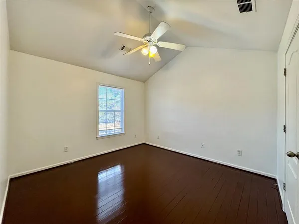an empty room with windows and fan