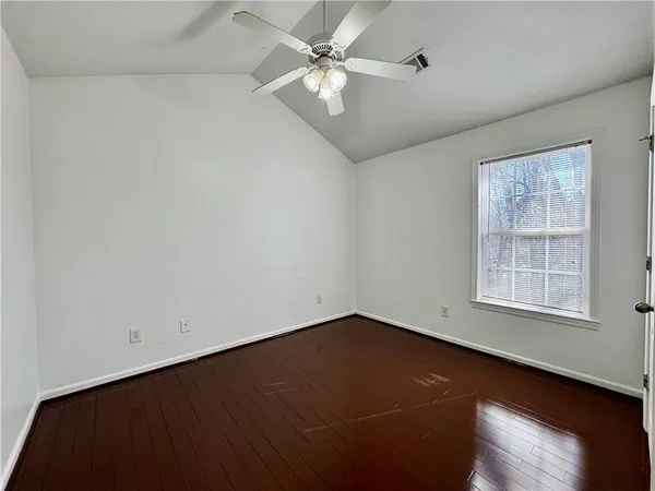 an empty room with a window and a ceiling fan