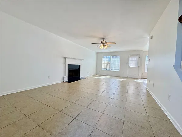 an empty room with windows and fireplace