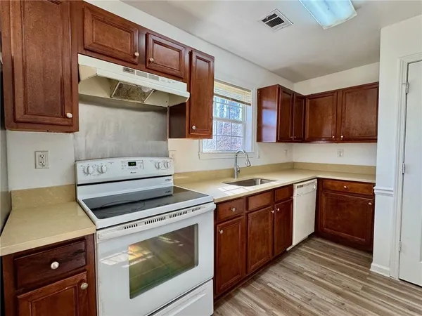 a kitchen with a stove sink and cabinets