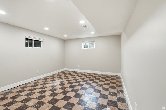 778 East 200 North Logan, UT 84321 - Photo 18 of 43 Spacious room featuring checkerboard flooring, light gray walls, recessed lighting, and two windows with white blinds