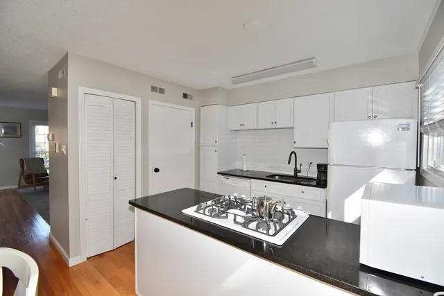 a view of a kitchen with kitchen island a sink stove and refrigerator