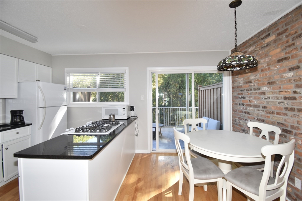 15 Yorktown Drive, Unit 15 Springfield, MA 01108 - Photo 9 of 22 a kitchen with stainless steel appliances granite countertop a stove a refrigerator a kitchen island a dining table and chairs