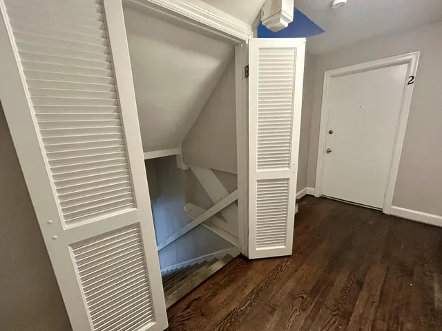 a view of a hallway with wooden floor and staircase