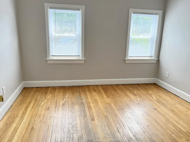 a view of a room with wooden floor and window