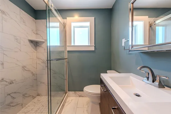 a bathroom with a sink a toilet and shower