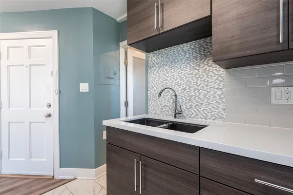 a close view of a sink a mirror and cabinets