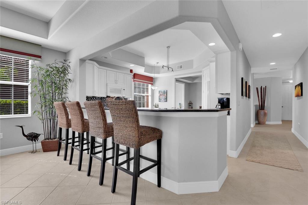 6413 Legacy Circle, Unit 1602 Naples, FL 34113 - Photo 11 of 34 a view of a dining room with furniture and a chandelier