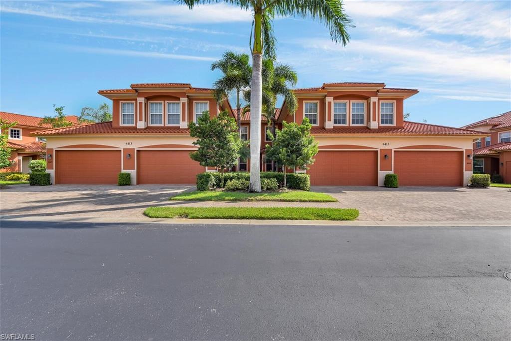 6413 Legacy Circle, Unit 1602 Naples, FL 34113 - Photo 2 of 34 a front view of a house with a yard and potted plants