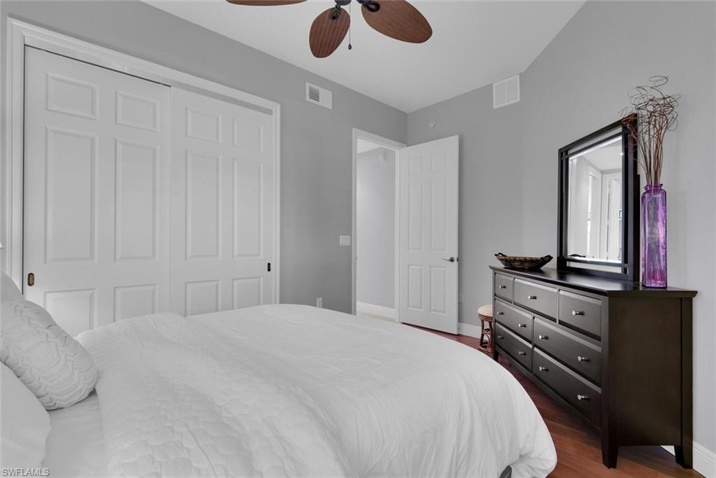 6413 Legacy Circle, Unit 1602 Naples, FL 34113 - Photo 22 of 34 a bedroom with a bed and a chandelier