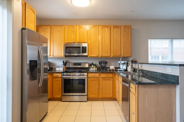 a kitchen with stainless steel appliances granite countertop a refrigerator and a sink