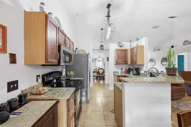 a kitchen with granite countertop a stove and a refrigerator