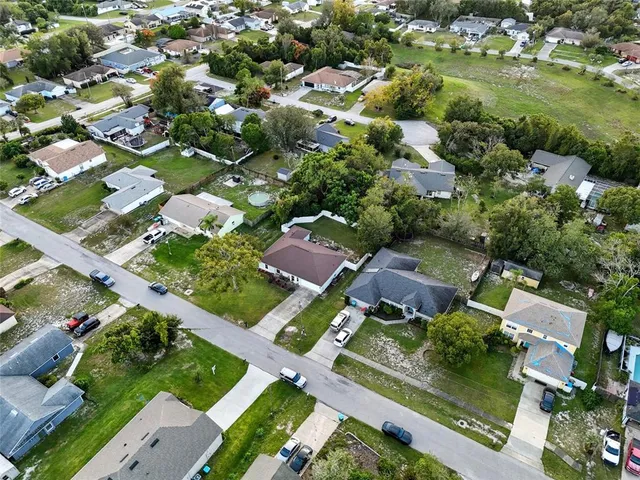 an aerial view of residential houses with outdoor space and trees