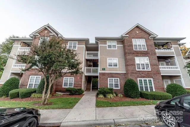 a front view of a residential apartment building with a yard