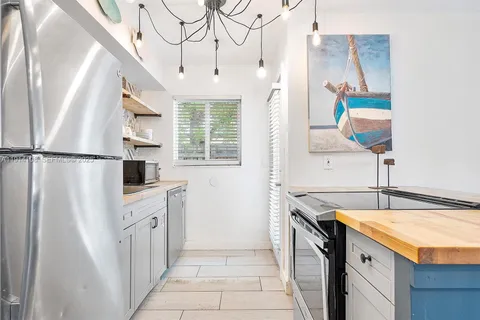 a kitchen with stainless steel appliances granite countertop a refrigerator a stove and a sink