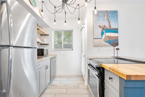 a kitchen with stainless steel appliances granite countertop a refrigerator a stove and a sink