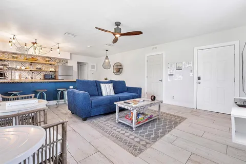 a living room with furniture and view of kitchen
