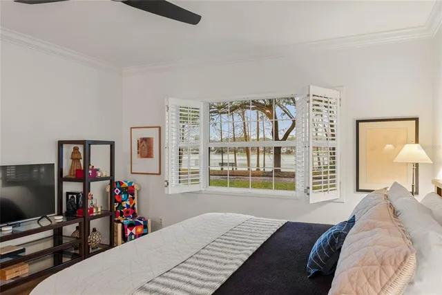 a bedroom with bed and a flat tv screen on dresser