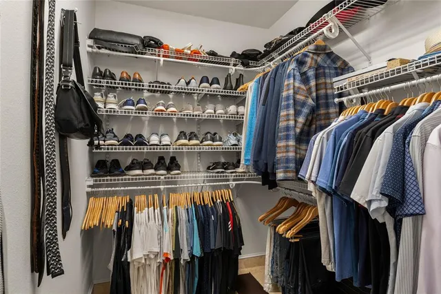 a view of walk in closet with clothes and shoes