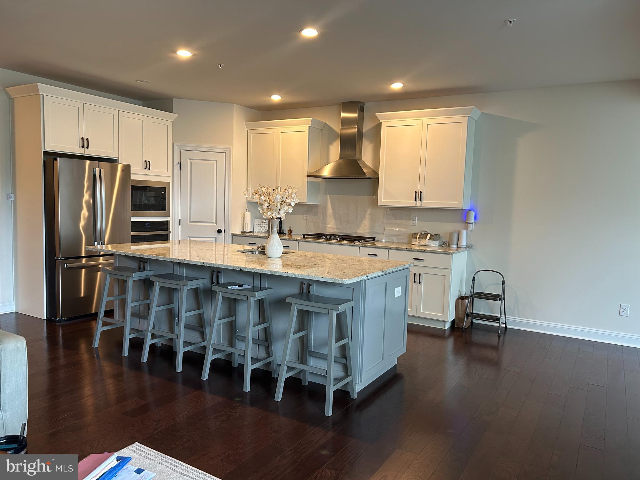 21 Midsummer Drive Newtown Square, PA 19073 - Photo 3 of 11 a kitchen with kitchen island granite countertop a stove a sink a refrigerator and island with wooden floor