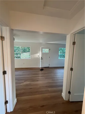 an empty room with wooden floor and window