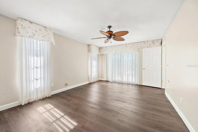 a view of a livingroom with wooden floor and windows
