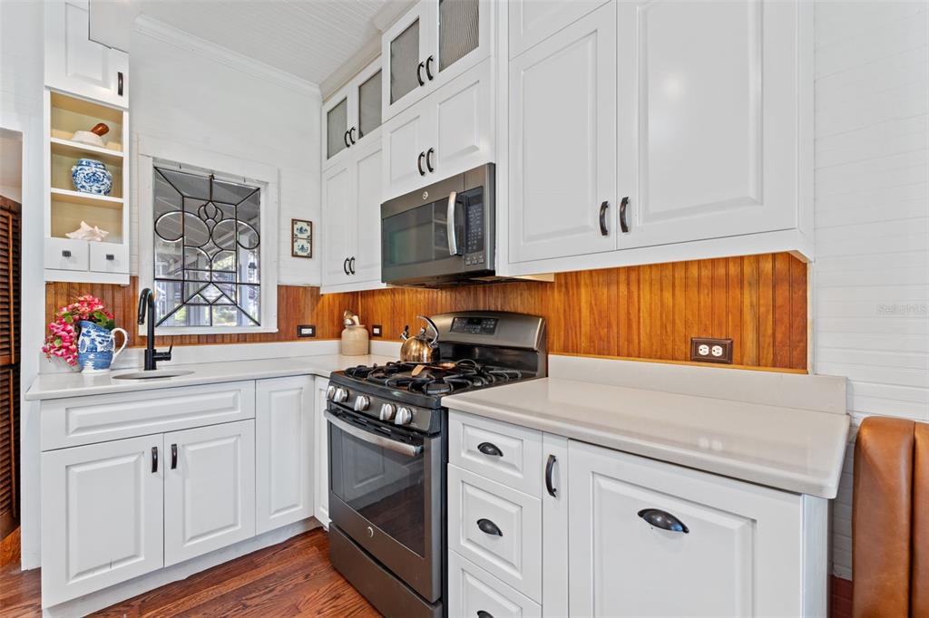 429 Scotland Street Dunedin, FL 34698 - Photo 21 of 78 a kitchen with stainless steel appliances white cabinets and a stove top oven