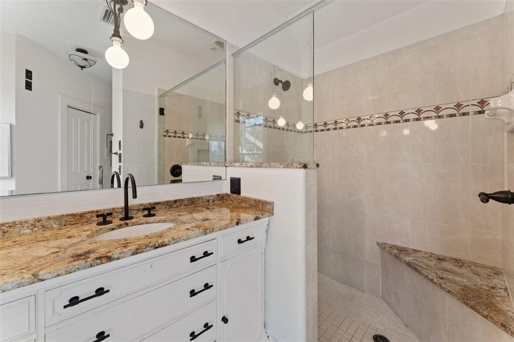 429 Scotland Street Dunedin, FL 34698 - Photo 38 of 78 a bathroom with a granite countertop sink a mirror and shower