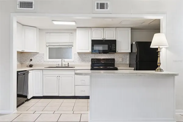 a kitchen with stainless steel appliances a stove sink microwave and cabinets