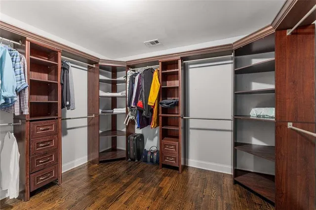 a view of walk in closet with clothes and shoes