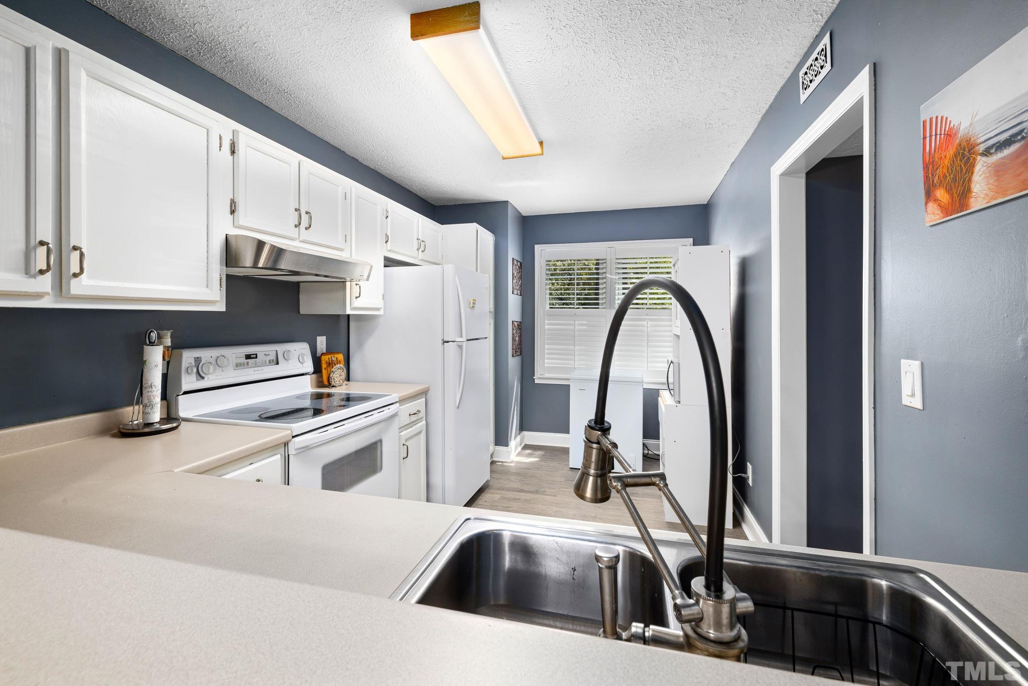 302 Broad Leaf Circle, Unit 302 Raleigh, NC 27613 - Photo 5 of 13 a kitchen with stainless steel appliances granite countertop a sink a stove and a refrigerator