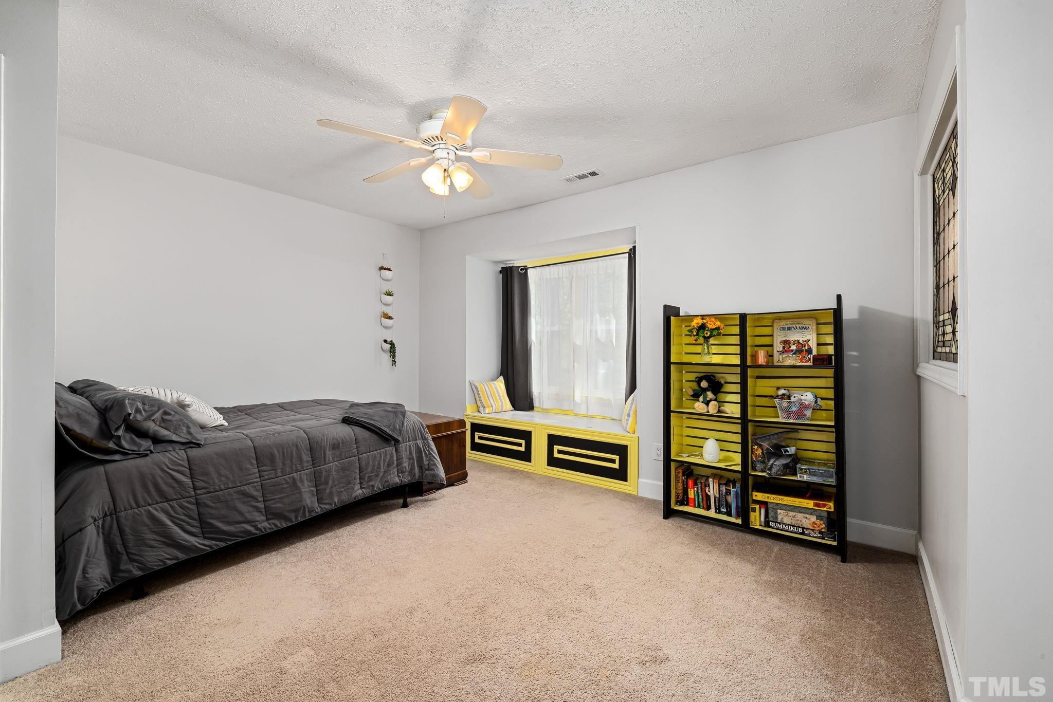 302 Broad Leaf Circle, Unit 302 Raleigh, NC 27613 - Photo 9 of 13 a spacious bedroom with a bed and a chandelier