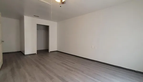 a view of an empty room with wooden floor
